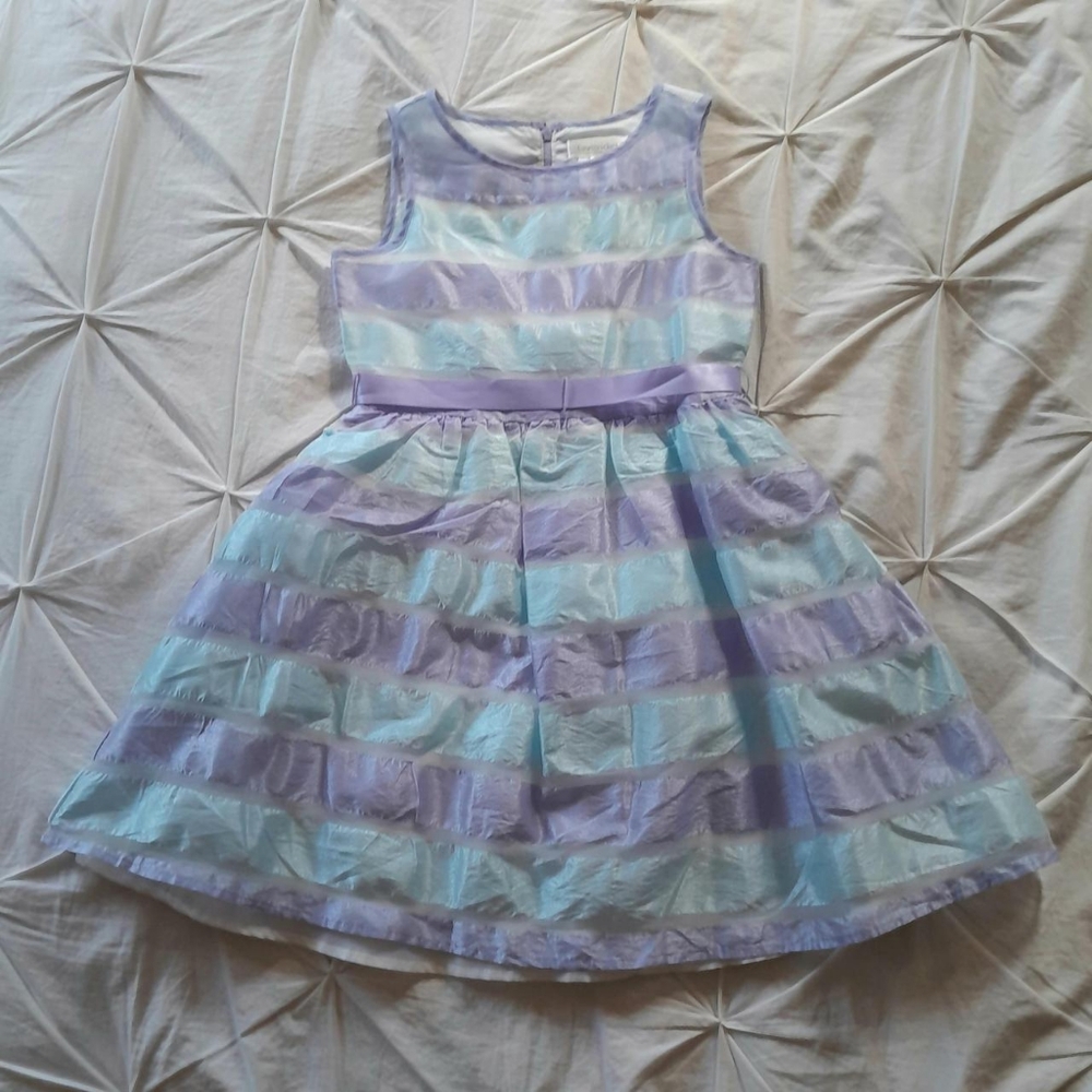 A blue, purple and white stripped dress with a purple ribbon to tie.
